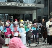 Kolędnicy śpiewają kolędy na placu przed Urzędem Miasta Legionowo