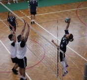 Zawody sportowe w siatkówkę. Dwie osoby wyskoczyły do bloku. Zawodniczka przeciwnej drużyny próbuje zbić piłkę. Zawody sportowe w siatkówkę. Dwie osoby wyskoczyły do bloku. Zawodniczka przeciwnej drużyny próbuje zbić piłkę.
