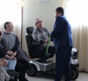 Prezydent wręcza męźczyznie na wózku inwalidzkim klucze do n Prezydent wręcza męźczyznie na wózku inwalidzkim klucze do n