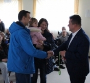 Prezydent wręcza rodzicom z dzieckiem klucze do nowego mieszkania. Prezydent wręcza rodzicom z dzieckiem klucze do nowego mieszkania.