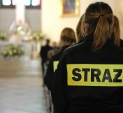 Zdjęcie z mszy. Na pierwszym planie osoba w kórtce strażackiej. W tle ołtarz kościoła garnizonowego Zdjęcie z mszy. Na pierwszym planie osoba w kórtce strażackiej. W tle ołtarz kościoła garnizonowego