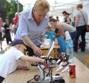 Na zdięciu dziecko z bliska ogląda robota. Na zdięciu dziecko z bliska ogląda robota.