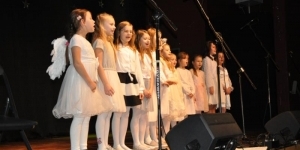 Chór dzieci przebrany za anioły podczas kolędowania