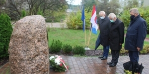 Oddanie hołdu przez trzech mężczyzn pod pomnikiem