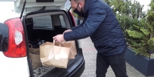 Mężczyzna wkładający paczki do bagażnika samochodu Mężczyzna wkładający paczki do bagażnika samochodu