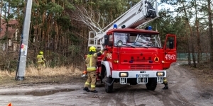 Wóz strażacki podczas interwencji zdejmowania przewróconego drzewa z linii wysokiego napięcia
