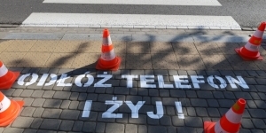 Na zdjęciu napis na chodniku - Odłóż telefon i żyj