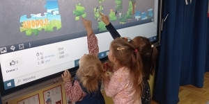 Na zdjęciu dwoje dzieci układają cyfrowe puzle na monitorze. Na zdjęciu dwoje dzieci układają cyfrowe puzle na monitorze.