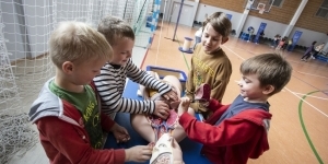 dzieci dotykają leżący model człowieka