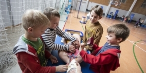 dzieci dotykają leżący model człowieka