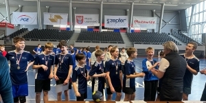 Drużyna chłopców w granatowych koszulkach odbiera nagrody