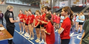 Drużyna dziewcząt w czerwonych koszulkach odbiera nagrody