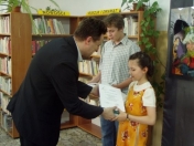 Piotr Zadrożny, Zastępca Prezydenta Miasta Legionowo wręcza dyplomy i nagrody Natalii Świrskiej i Jakubowi Skarpetowskiemu, wyróżnionym w kategorii proza.