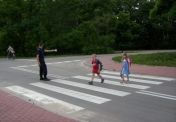 Strażnik miejski pomagający dzieciom w przejściu przez jezdnię