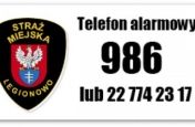 Grafika z herbem Straży Miejskiej i numer alarmowym 986