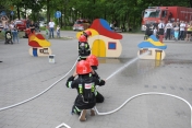 Na zdjęciu strażak pokazuje jak gasić zainscenizowany pożar w specjalnie przygotowanym do tego miasteczki.