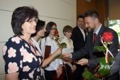 Na zdjęciu laureaci konkursu otrzymują od prezydenta różę i dyplomy