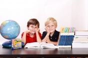Na zdjęciu dwójka dzieci przy biurku do nauki