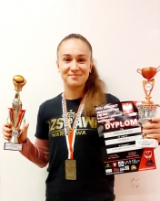 Paulina Saczuk trenująca Kickboxing trzyma w rękach puchary