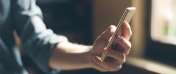Na zdjęciu osoba trzymająca w ręku telefon
