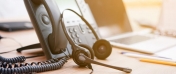 Telefon stacjonarny oraz słuchawki. Źródło zdjęcia: gov.pl