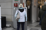 Na zdjęciu mieszkanka korzystająca z kolejkomatu