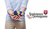 Osoba z nakrętkami w rękach i napisem - Legionowo nakręca do pomagania