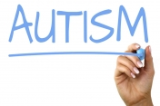Niebieski napis flamastrem na szkle - autism.