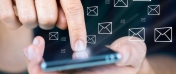 Palec wskazuje na ekran w urządzeniu mobilnym, typu smartphone.