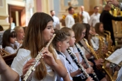 Grupa dziewcząt gra na różnych instrumentach dętych.