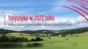 Krajobraz z pagórkami, napis: Turystyka w 2022 r.