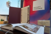 Apel w obronie manuskryptu na tle roll-upu Województwa Kujawsko-Pomorskiego