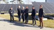 Sześciu mężczyzn na tle paneli fotowoltaicznych