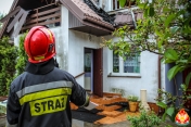 Strażak, w tle dom