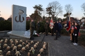 Żołnierze przy pomniku, a także kilka innych osób i sztandary