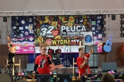 Dwie osoby z mikrofonami na tle banneru 32 finału WOŚP
