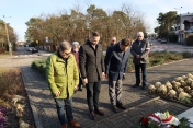 Na zdjęciu trzy osoby składająće kwiaty