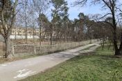 Ścieżka dla pieszych i rowerzystów, obok ogrodzenie; teren przy ul. Piaskowej