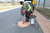 Robotnik podczas wykonywania prac w asfalcie
