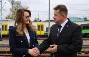 Na zdjęciu dwie osoby na tle pociągu