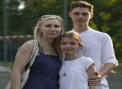 troje dzieci stoi i przytula się