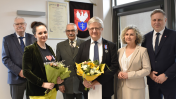 grupa ludzi pozuje do zdjęcia . dwie osoby trzymają bukiety