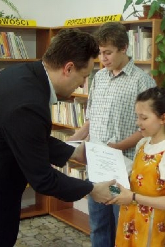 Piotr Zadrożny, Zastępca Prezydenta Miasta Legionowo wręcza dyplomy i nagrody Natalii Świrskiej i Jakubowi Skarpetowskiemu, wyróżnionym w kategorii proza.