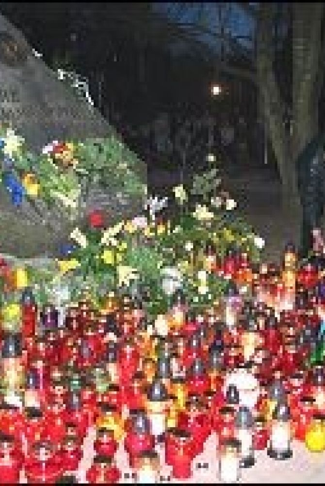 Modlący się zapalali przed rozpoczęciem różańca znicze pod pamiątkowym kamieniem w Parku Jana Pawła II