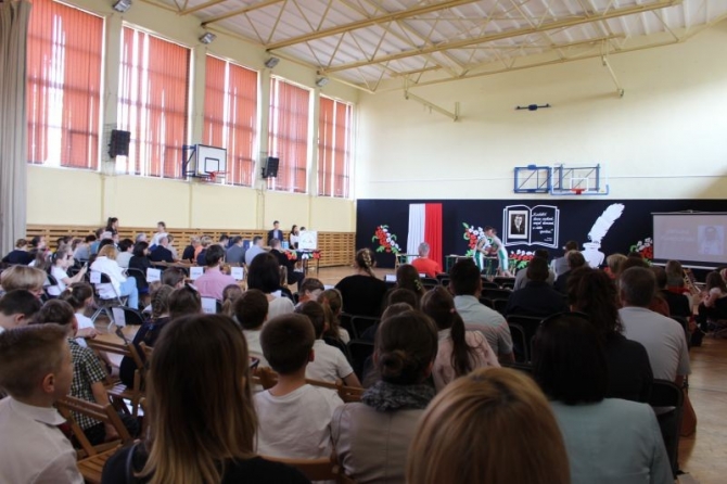 Na zdjęciu goście zebrani na sali gimnastycznej oglądają przedstawienie.