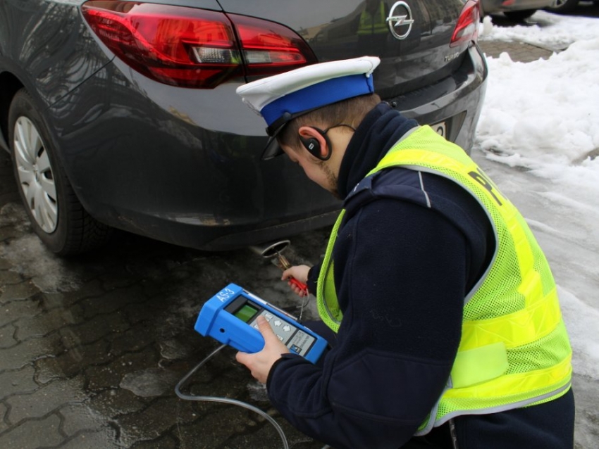 Policjant podczas pomiaru emisji spalin