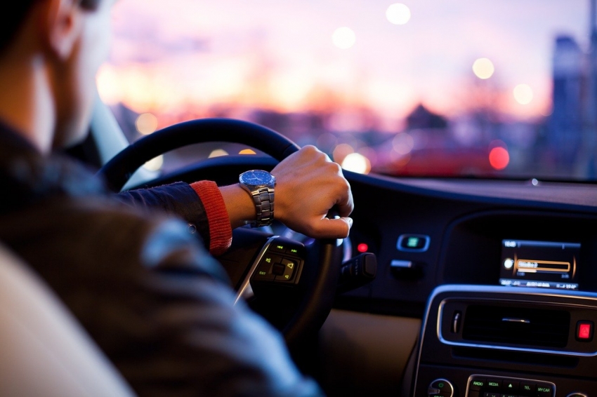 Grafika wyróżniająca z kierującym auto mężczyzną