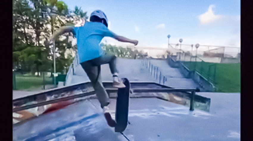 Skatepark. Na nim osoba, która zdobyła 1. miejsce w konkursie wykonująca ewolucję na deskorolce.