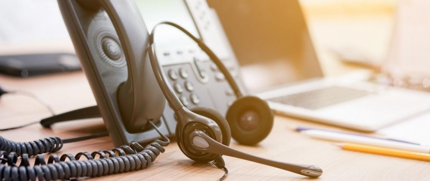 Telefon stacjonarny oraz słuchawki. Źródło zdjęcia: gov.pl