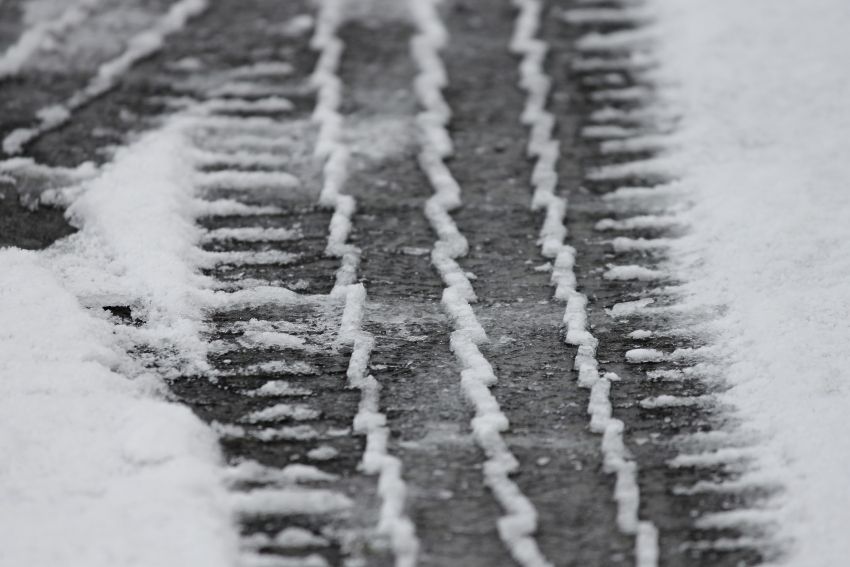 Ślady opon samochodu na śniegu